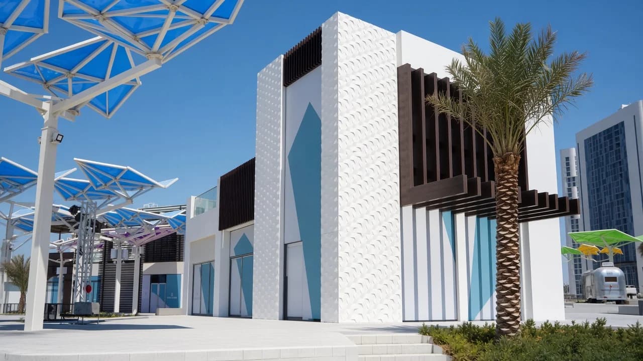 White GRC facade with textured decorative wall cladding and palms