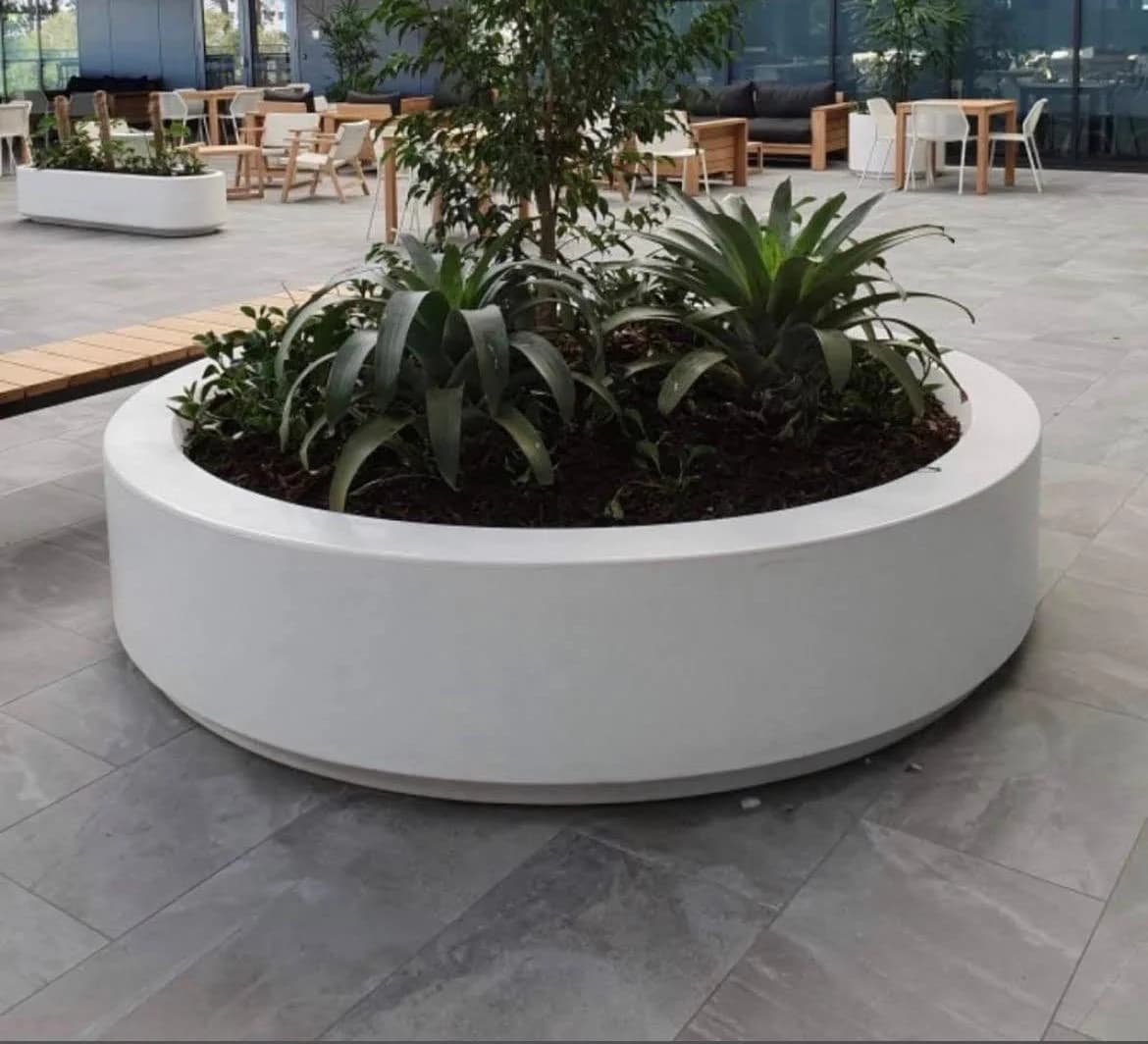 Large circular white planter in a seated courtyard