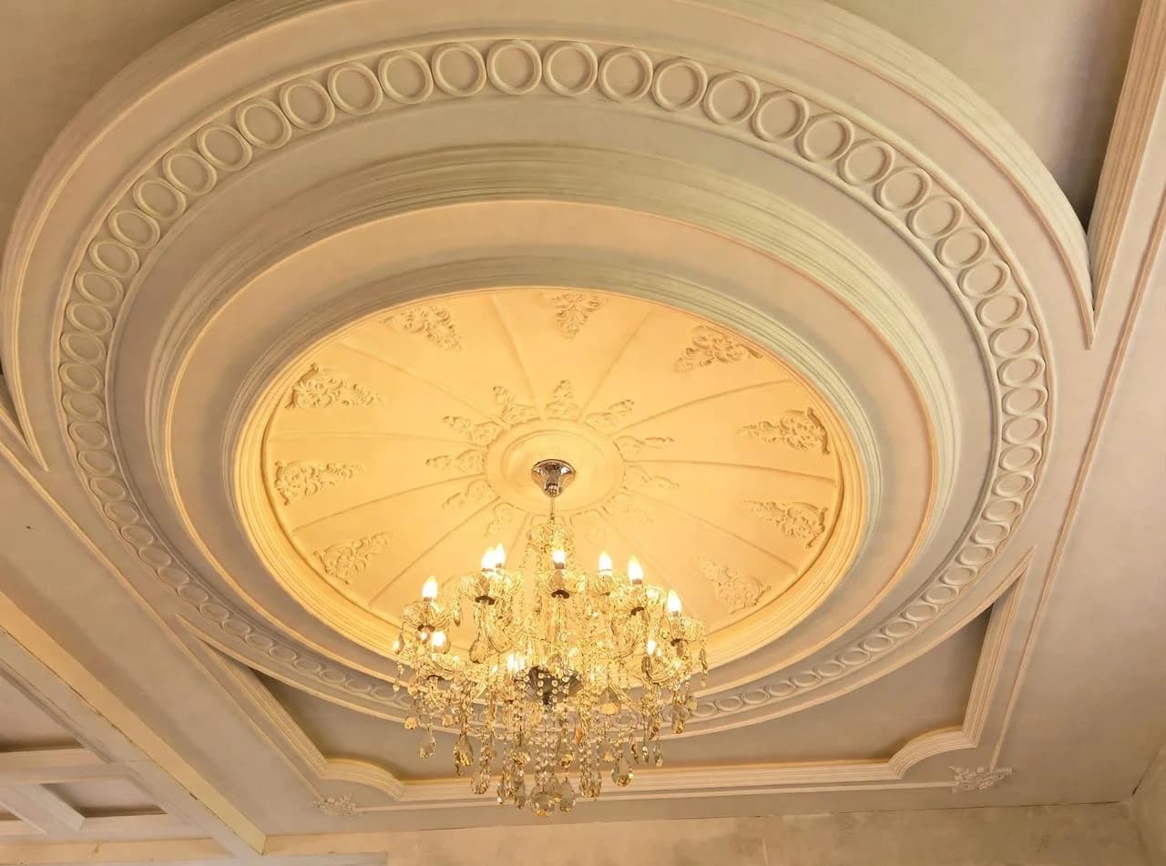 Warm GRG ceiling rose with a crystal chandelier